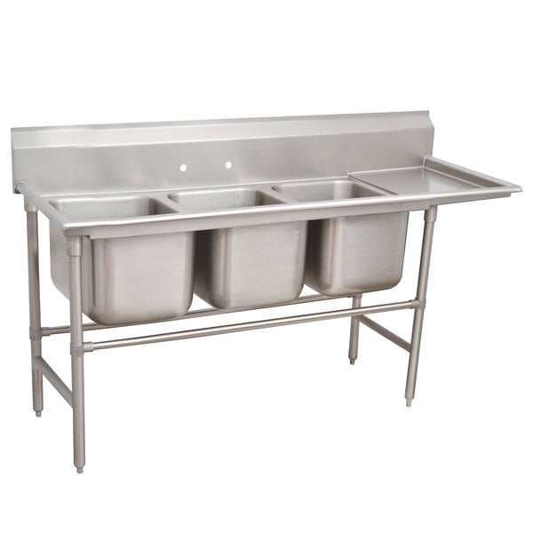 A stainless steel Advance Tabco three compartment sink with right drainboard.