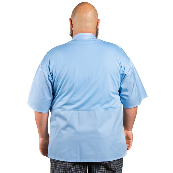 A man wearing a sky blue Uncommon Chef Venture Pro Vent chef coat.