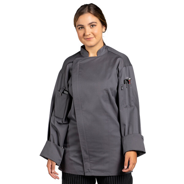 A woman wearing an Uncommon Chef grey long sleeve chef coat with a mesh back.