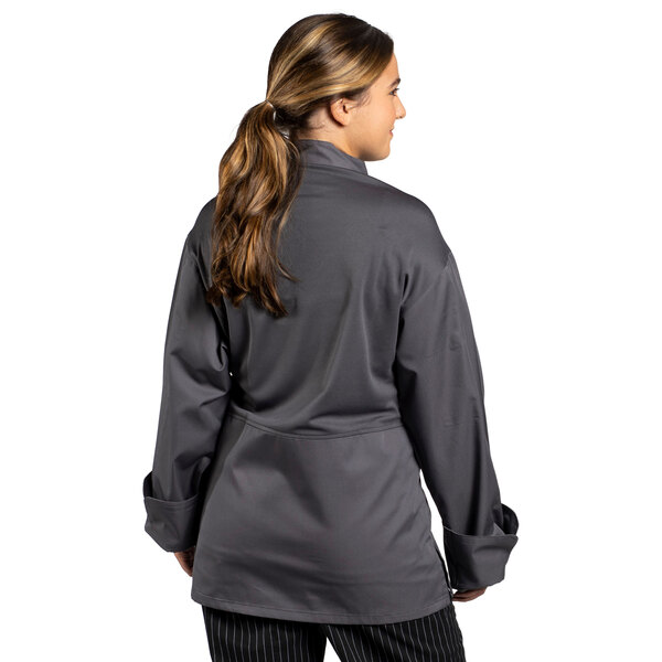 A woman wearing a Uncommon Chef grey long sleeve chef coat with mesh back.
