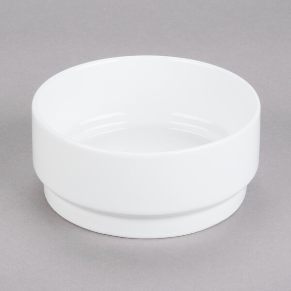 A white Arcoroc stackable bowl on a gray surface.