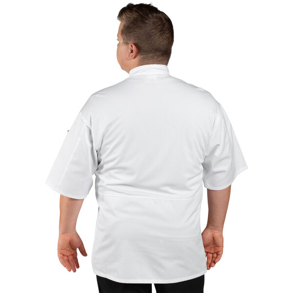 A man wearing a white Uncommon Chef Venture Pro chef coat with a white collar and mesh back.