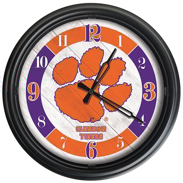 A Holland Bar Stool Clemson Tigers wall clock with a paw print logo.