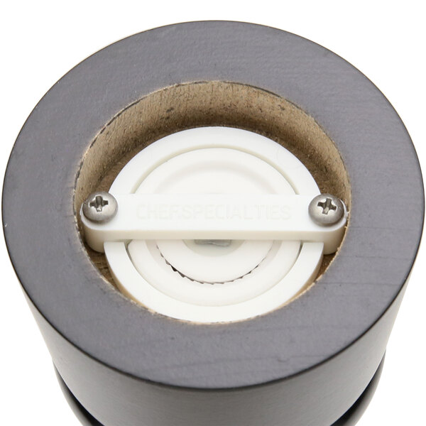 A close up of a white circular object with a screw in it.