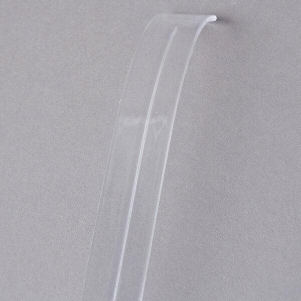 A clear plastic tube with a clear plastic ladle inside.