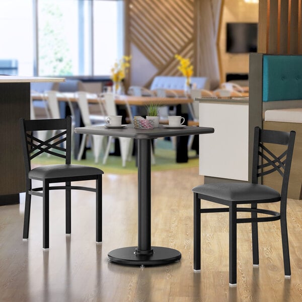 A Lancaster Table & Seating reversible gray and white laminated table top on a table with white cups and a coffee basket.