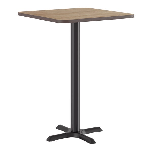 A square bar height table with a reversible white birch or ash laminated top and a black cast iron base.