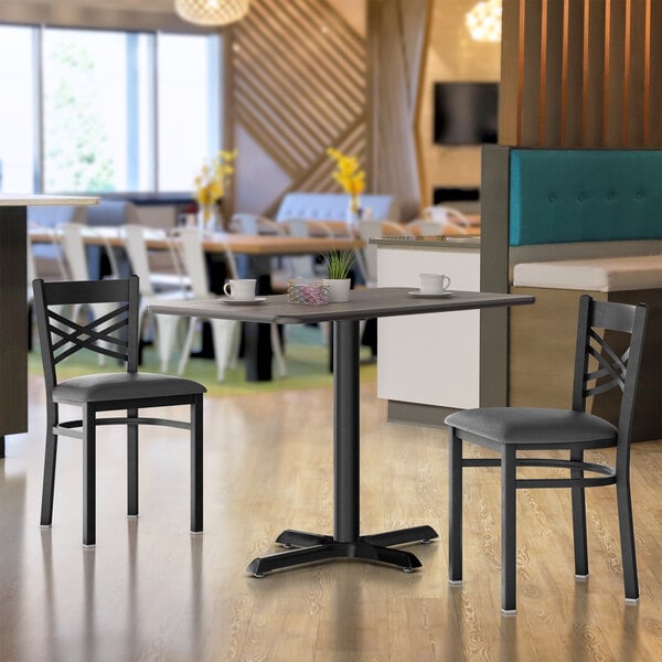 A Lancaster Table and Seating white table and base in a restaurant dining area.