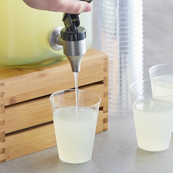 A person pouring Ruby Kist lime juice into a glass.