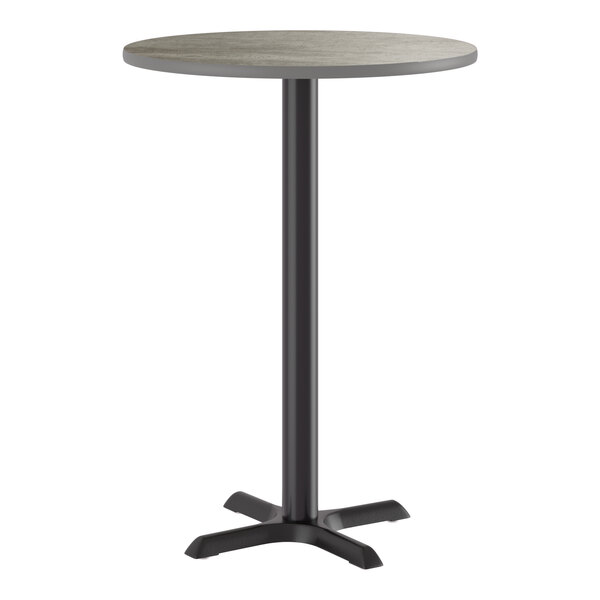 A round bar height table with a reversible gray and white laminated top and a black cast iron base.