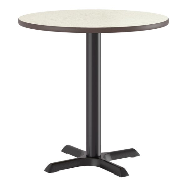 A round standard height table with a reversible white birch or ash laminated top and a black cast iron base.