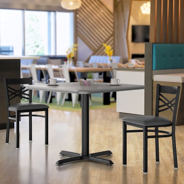 A Lancaster Table & Seating reversible gray and white table top with a white cup on it.
