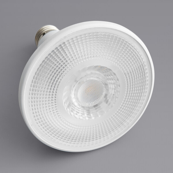 A close up of a TCP PRO LED PAR38 light bulb with white light on.