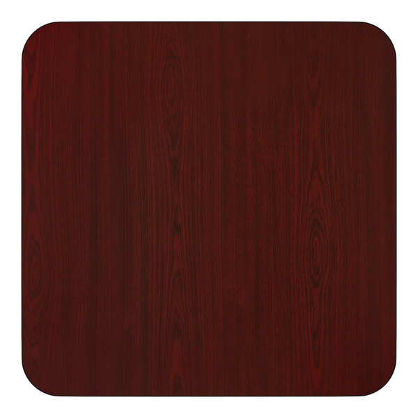 A square, reversible laminated table top with a cherry wood finish and rounded corners.
