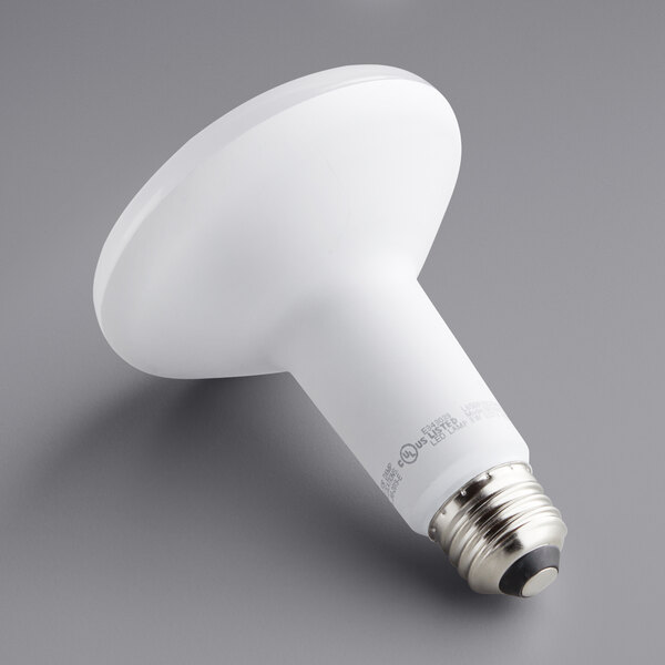 A TCP BR30 LED light bulb on a gray surface.