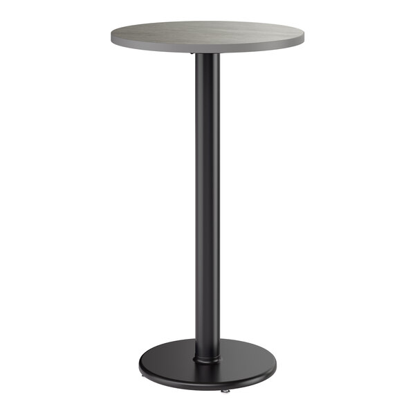 A round bar height table with a reversible gray or white laminated top and a black cast iron base.