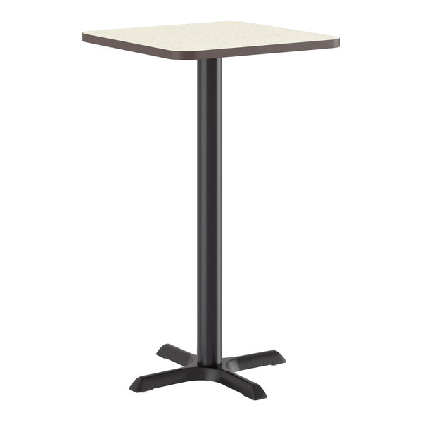 A square bar height table with a light wood-colored top and a black cast iron base.
