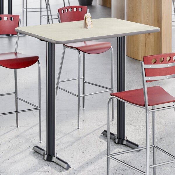 A rectangular bar height table with a reversible gray and white laminated top and a black cast iron base.