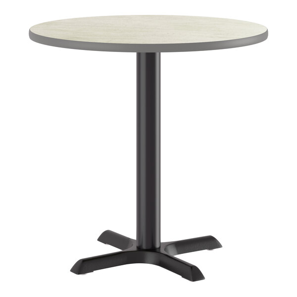 A round standard height table with a reversible gray or white laminated top and a black cast iron base.