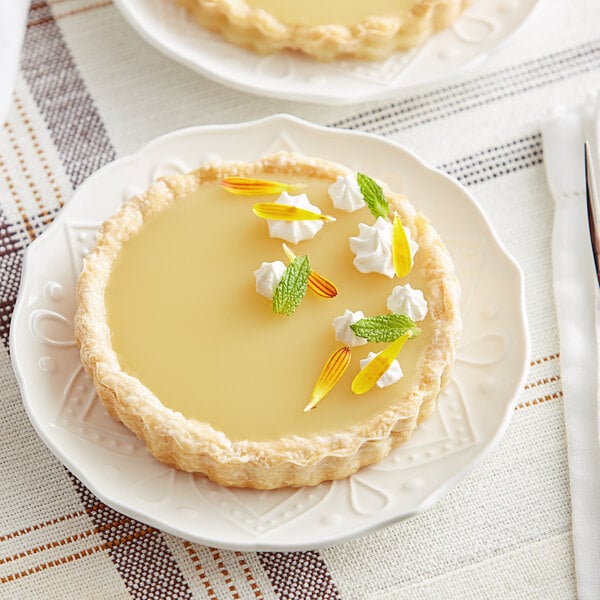 Two small tarts with Les Vergers Boiron Yuzu fruit puree on white plates.