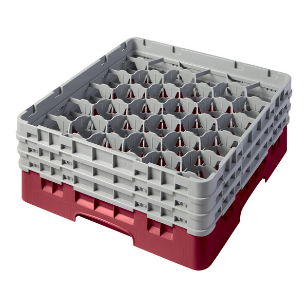 A white plastic Cambro glass rack with many compartments and 3 red extenders.