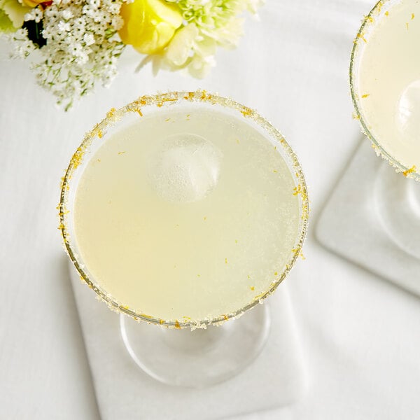 Two martini glasses with Les Vergers Boiron Bergamot puree and ice on a table.