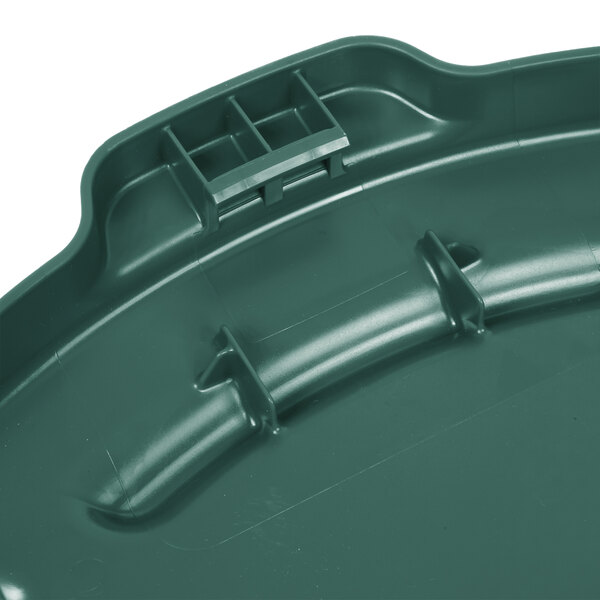 A close-up of a green Rubbermaid BRUTE trash can lid.