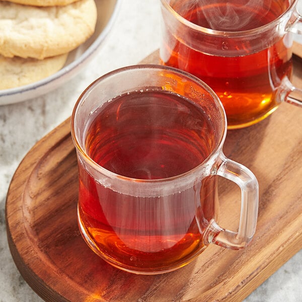 A wooden tray with two Twinings Pure Rooibos tea K-Cups and cookies.