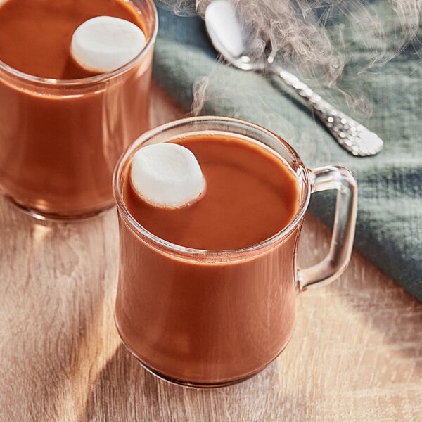 A close-up of two mugs of Ghirardelli Double Chocolate hot cocoa with marshmallows on top.