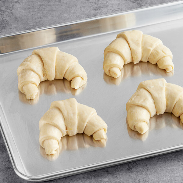 A Schulstad curved butter croissant on a metal tray.