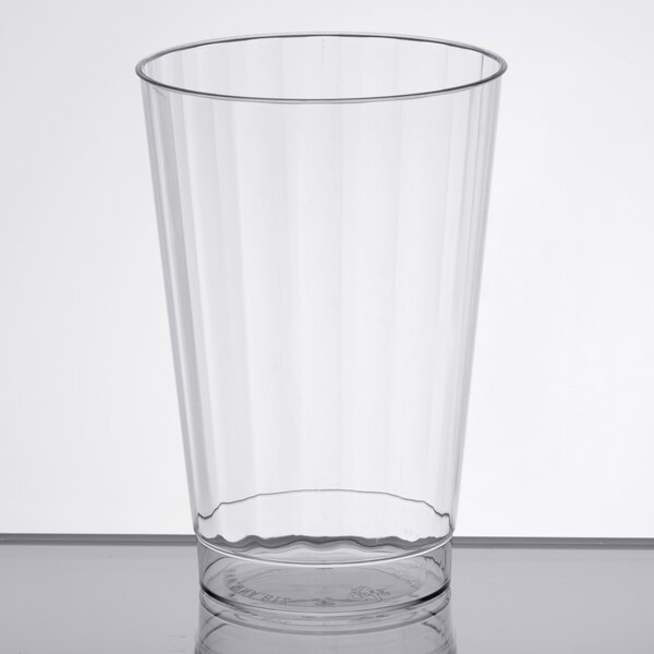 A WNA Comet clear plastic fluted tumbler on a table.