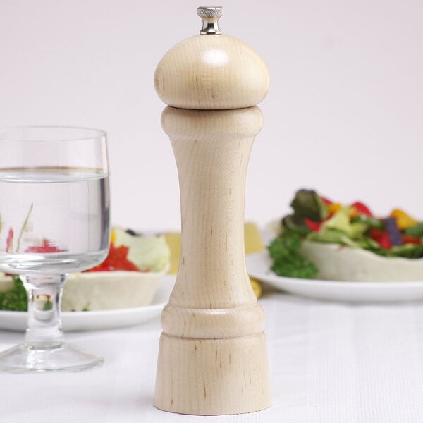 A close-up of a Chef Specialties Windsor natural maple salt mill on a table.