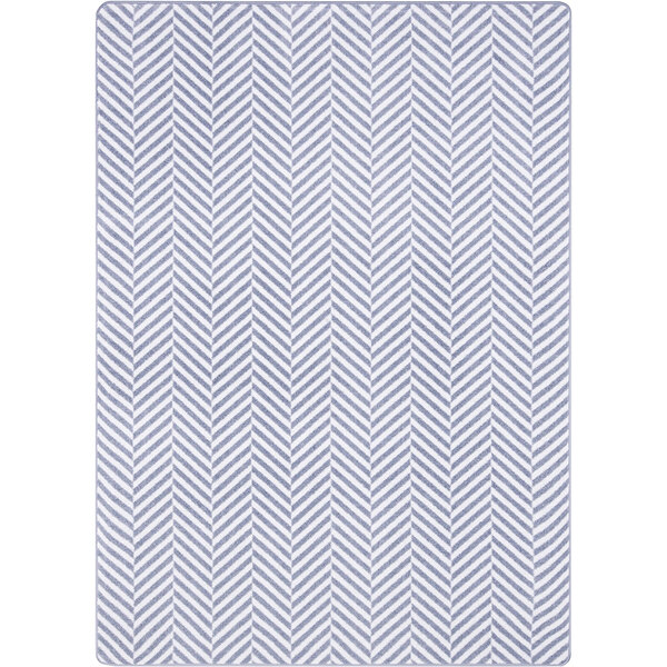 A white rectangular area rug with a grey chevron pattern.