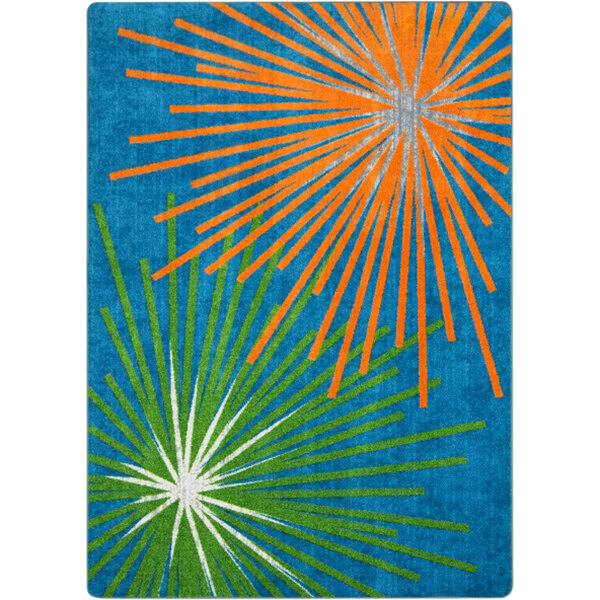 A blue rug with orange, green, and blue starbursts and white rays.