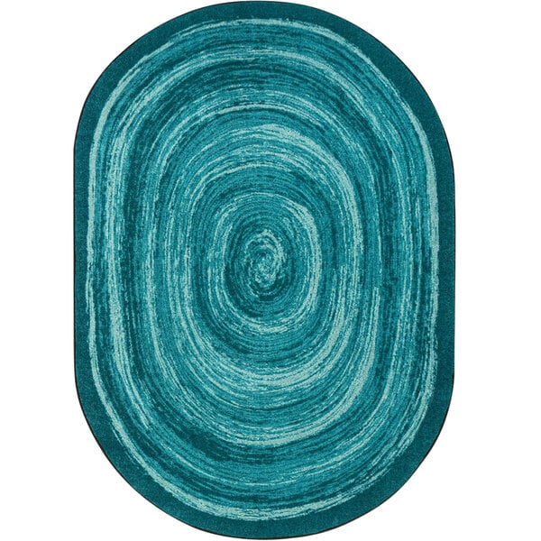 A teal oval rug with a circular design in blue and white.