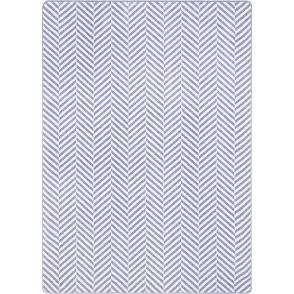 A white rectangular area rug with a grey chevron pattern.