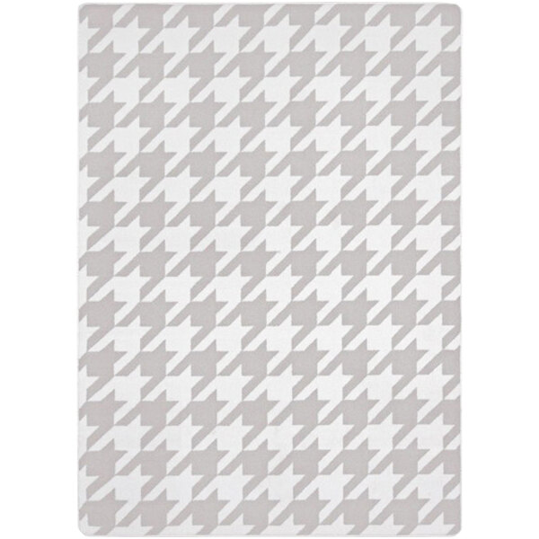 A grey and white houndstooth rug with a white background.