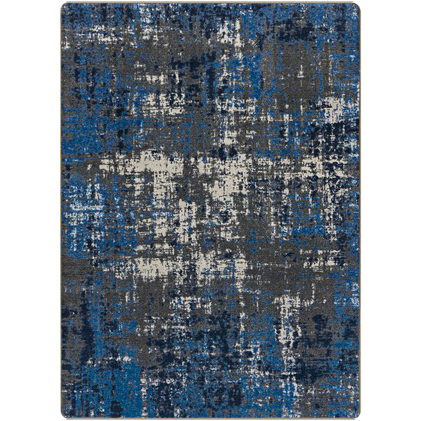 A close-up of a Joy Carpets blue and grey rectangular area rug with a pattern.