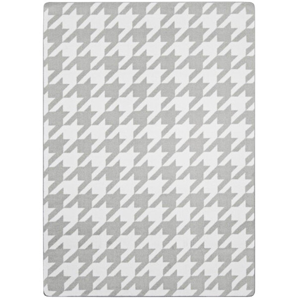 A grey and white houndstooth patterned fabric rug.