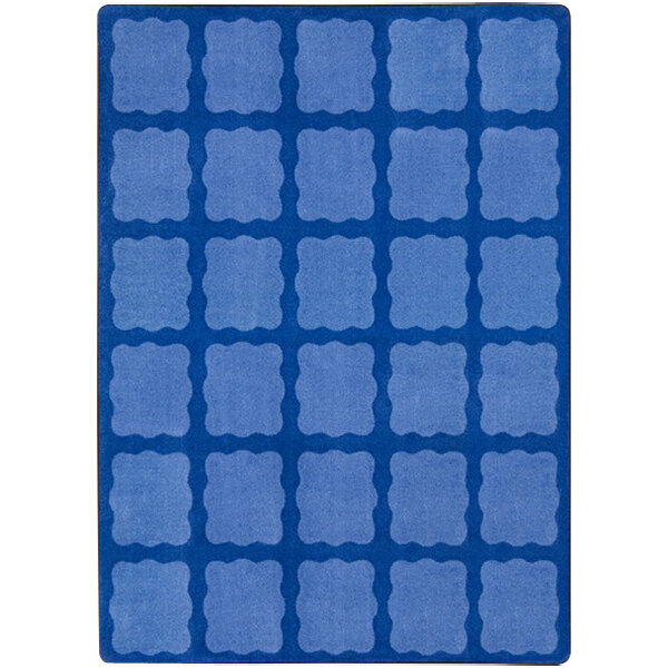 A blue rug with multicolored squares on it.