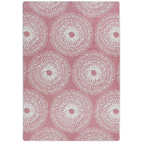 A white and pink rectangular area rug with circular designs in pink and white.