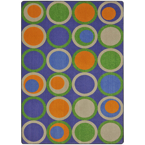 A Joy Carpets rectangle area rug with colorful circles on it.