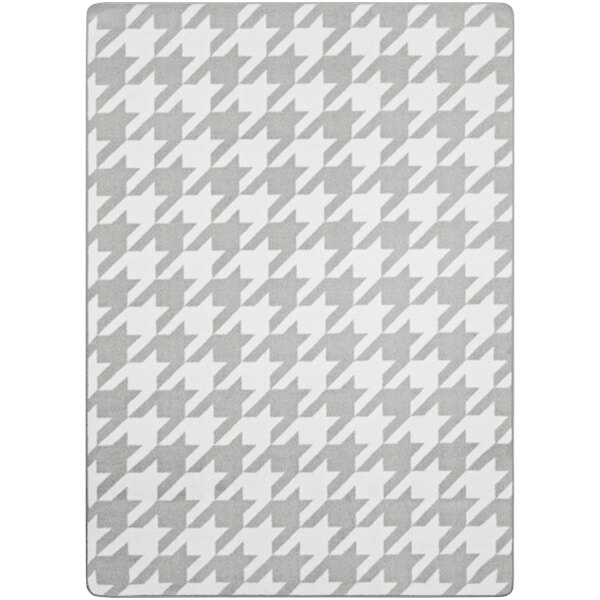 A grey and white houndstooth rug with a white border.