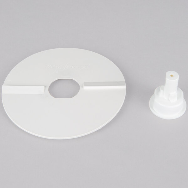 A white plastic circular disc with a hole in it.