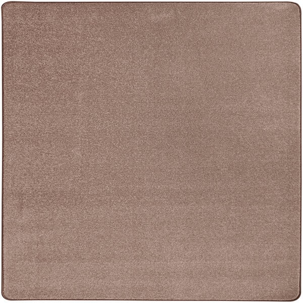 A close-up of a taupe square area rug with a brown background.