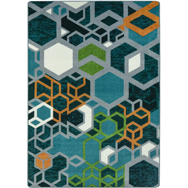A close-up of a citrus area rug with hexagons and squares in blue, white, and black.
