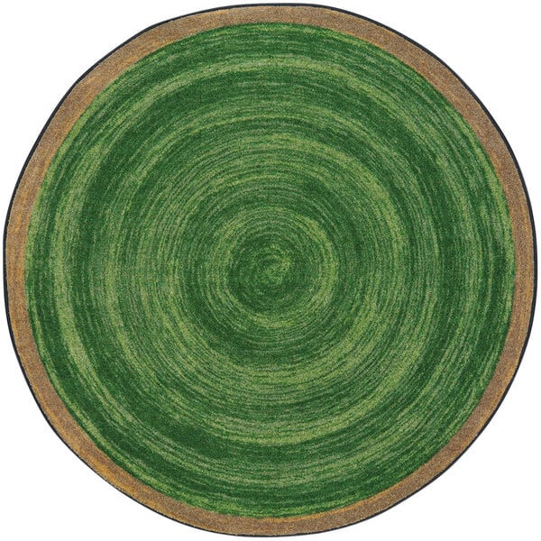 A green circular rug with a circular pattern in brown and green.