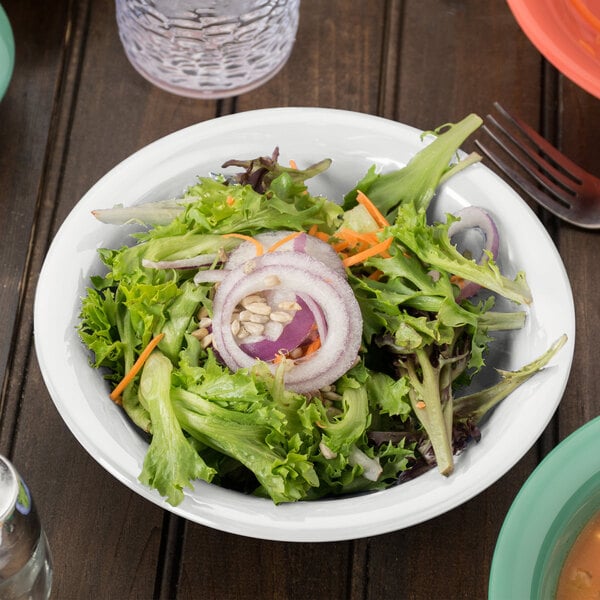 A bowl of salad with onions and carrots.