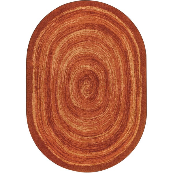 An orange oval Joy Carpets area rug with a circular design.