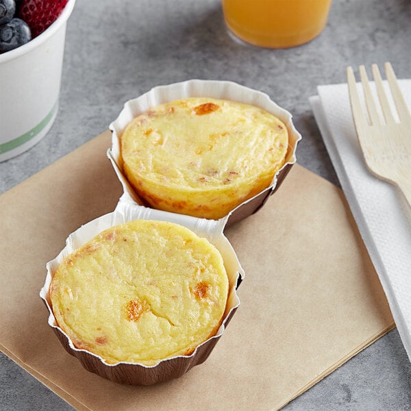 Artisan Kitchens Bacon and Three Cheese Egg Bites in two small cups on a counter.